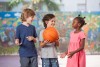 Niños jugando con una pelota de baloncesto